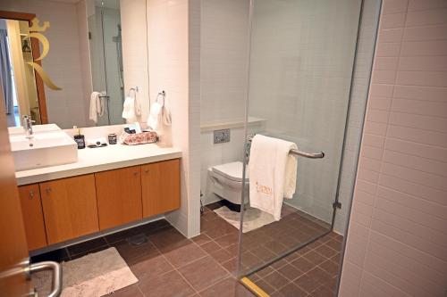 a bathroom with a sink and a toilet and a shower at Luna Breeze - Elegant 2BR Apartment with Beach Access, Near Al Raha Beach in Abu Dhabi