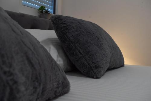 two pillows sitting on top of a bed at Lux Apartment III Prijedor in Prijedor