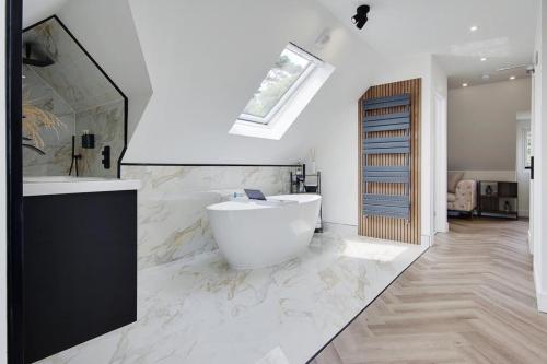 a white bathroom with a tub and a sink at Mount Lodge in Bournemouth