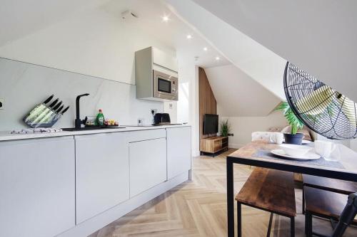 a kitchen with white cabinets and a dining table at Mount Lodge in Bournemouth