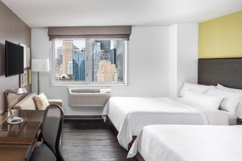 a hotel room with two beds and a window at Element Times Square West in New York