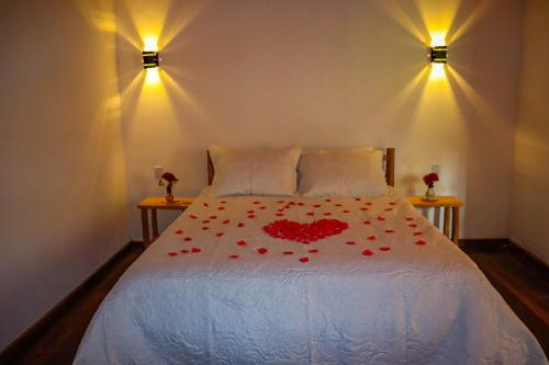 a bedroom with a bed with red roses on it at Montanhas Do Visconde in Visconde De Maua