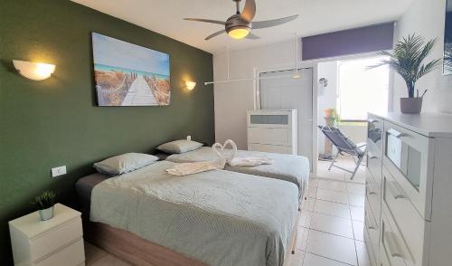 Un dormitorio con dos camas y una pared verde. en Buena Vista Yaco, en San Isidro