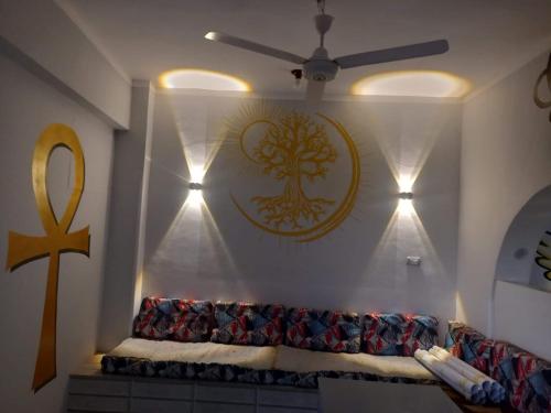 sala de estar con sofá y un símbolo en la pared en Royal Apartments Luxor, en Luxor