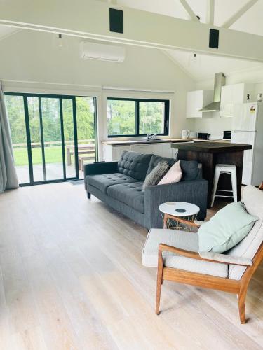 a living room with a couch and a table at Stunning 2 bedroom Guesthouse in Tamahere