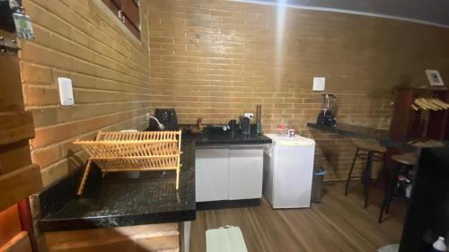 eine Küche mit einer Theke und einem Waschbecken in einem Zimmer in der Unterkunft Lar do sertão- flat dentro do Hotel Fazenda Pedra do Rodeadouro in Bonito