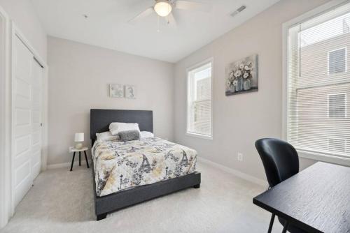 um quarto com uma cama, uma mesa e uma cadeira em Spacious 3Bedroom Duplex with Rooftop Deck! em Washington
