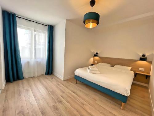 um quarto com uma cama e uma grande janela em Les fauvettes - Centre ville em Épernay