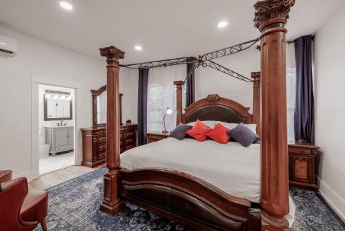 a bedroom with a large wooden bed with red pillows at Mountain Manor Sandy HotTub, 3KingBeds, Ski Mt Hood in Sandy