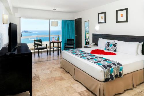 a bedroom with a bed and a view of the ocean at Krystal Ixtapa in Ixtapa