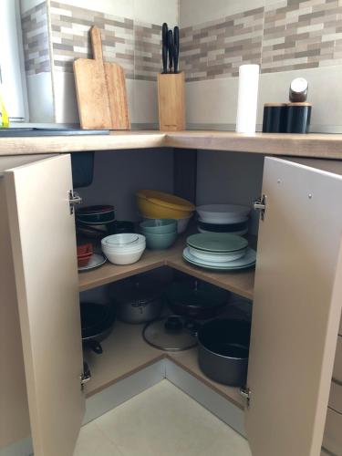 a kitchen cabinet filled with dishes and utensils at Casa Eroilor in Curtea de Argeş