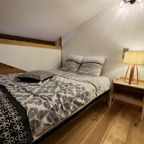 une chambre avec un lit et une lampe sur une table dans l'établissement Le Notre-Dame - Centre-ville, à Montauban