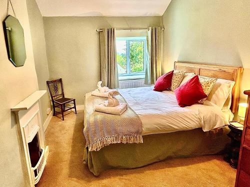 a bedroom with a bed with a stuffed animal on it at Springbank Cottage in Stroud