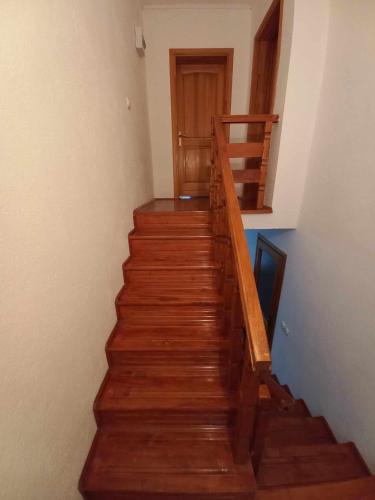 a stairway with wooden stairs and a wooden door at Vikendica Savić in Šipovo