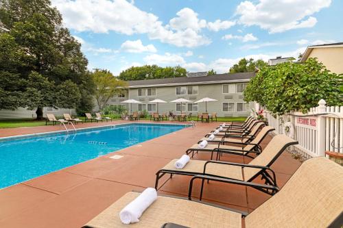 una piscina con sedie a sdraio accanto a un edificio di Best Western Plus Windjammer Inn & Conference Center a Burlington