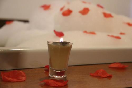 a candle in a glass sitting on a table at Montanhas Do Visconde in Visconde De Maua