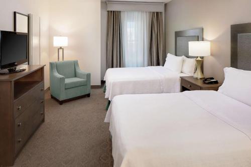 a hotel room with two beds and a television at Homewood Suites by Hilton Dallas Market Center in Dallas