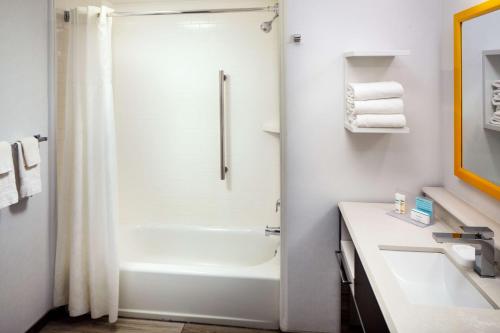 a white bathroom with a shower and a sink at Hampton Inn & Suites Parker in Parker