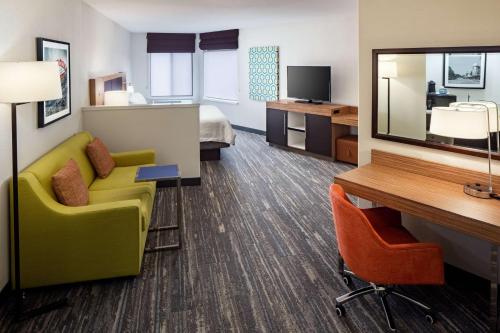 a hotel room with a couch and a desk and a bed at Hampton Inn & Suites Parker in Parker