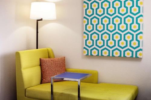 a yellow chair with a table next to a painting at Hampton Inn & Suites Parker in Parker