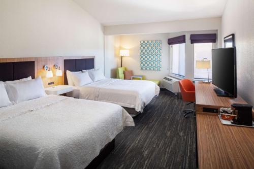 Habitación de hotel con 2 camas y TV de pantalla plana. en Hampton Inn & Suites Parker en Parker