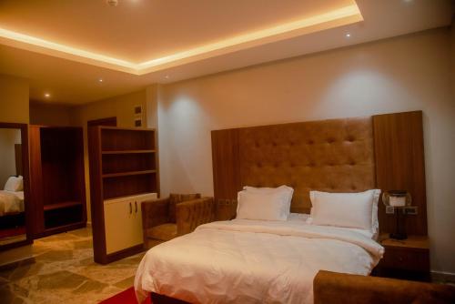 a hotel room with a large bed with white sheets at DALOBI HOTEL AND SUITES 