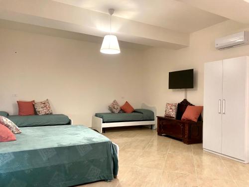 Habitación con 2 camas, sofá y TV. en La Vista del Mare - Puglia Mia Apartments, en Monopoli