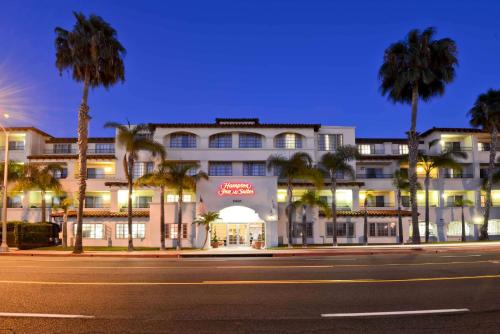 a building with palm trees in front of a street at Hampton Inn & Suites San Clemente in San Clemente