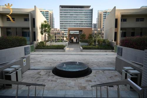 a courtyard with a fountain in the middle of a building at Luna Breeze - Elegant 2BR Apartment with Beach Access, Near Al Raha Beach in Abu Dhabi