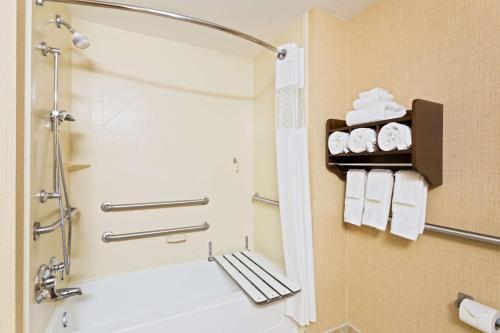 een badkamer met een douche en een bad met handdoeken bij Hampton Inn Leesburg Tavares in Leesburg