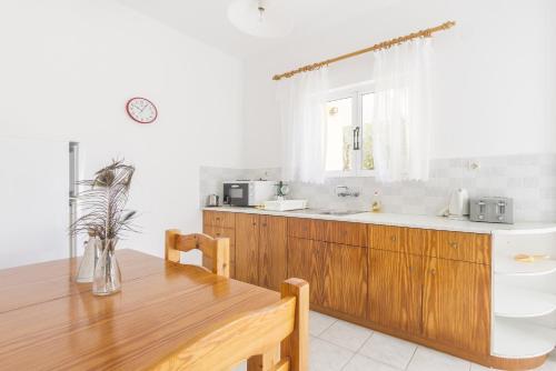 a kitchen with a wooden table and a sink at Olive Grove Apts in Lithakia
