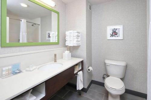 a bathroom with a toilet and a sink with a mirror at Hampton Inn & Suites Tucson East in Tucson