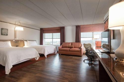 una habitación de hotel con 2 camas y una silla en Hilton Garden Inn Owings Mills en Owings Mills