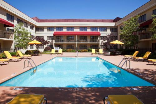 a swimming pool with chairs and a building at DoubleTree Suites by Hilton Hotel Cincinnati - Blue Ash in Sharonville