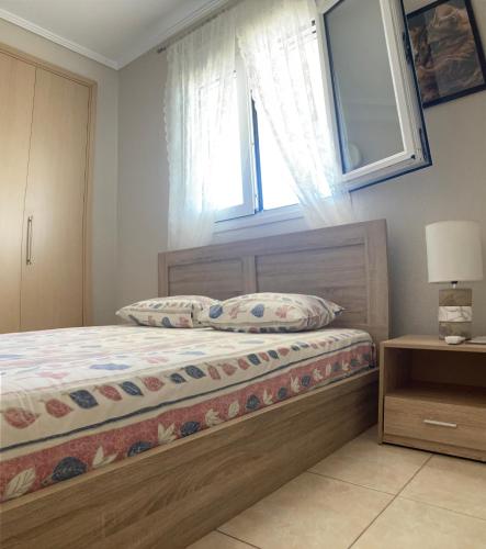 a bedroom with a wooden bed with a window at Small apartment, great view! in Veria