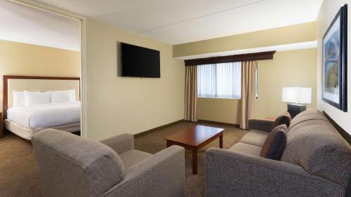 a hotel room with a bed and a living room at DoubleTree Suites by Hilton Hotel Cincinnati - Blue Ash in Sharonville