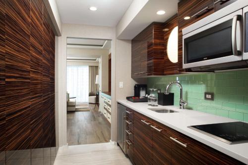una cocina con fregadero y microondas en Conrad Fort Lauderdale Beach, en Fort Lauderdale
