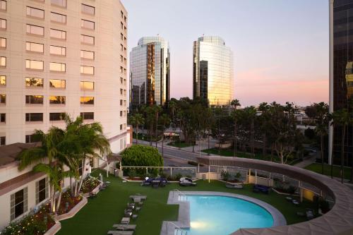 Vista ariale di una piscina in una città con edifici alti di Hilton Long Beach Hotel a Long Beach