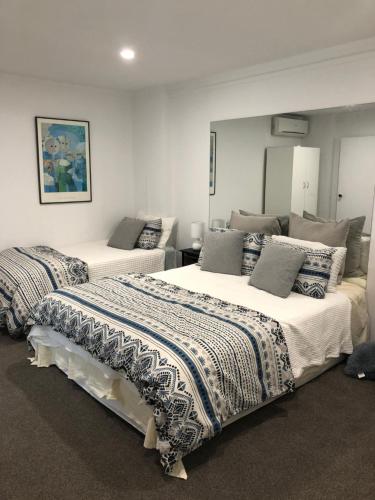 a bedroom with two beds with pillows on them at Waikaraka Beach, spacious & very comfortable in Whangarei Heads