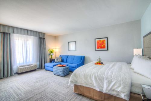 ein Hotelzimmer mit einem Bett und einem blauen Sofa in der Unterkunft Hampton Inn Houston I-10 East, TX in Houston