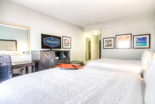 a hotel room with two beds and a desk at Hampton Inn Houston I-10 East, TX in Houston