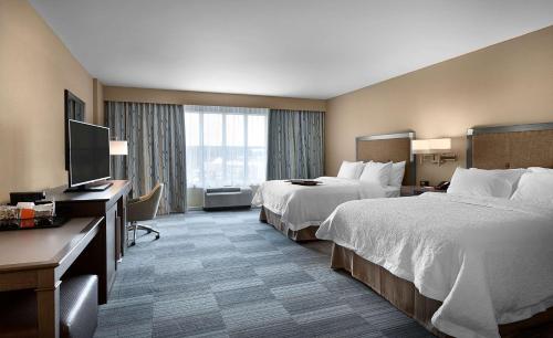 a hotel room with two beds and a flat screen tv at Hampton Inn and Suites Fort Mill, SC in Fort Mill