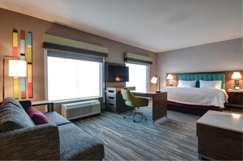 Habitación de hotel con cama y sofá en Hampton Inn & Suites Canal Winchester Columbus en Canal Winchester