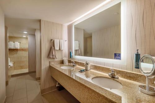 baño con 2 lavabos y espejo grande en DoubleTree by Hilton Lawrence en Lawrence