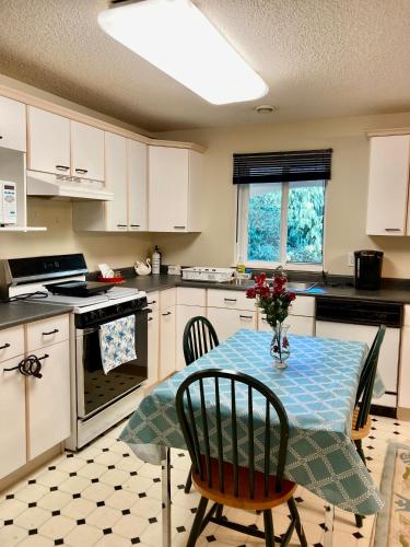 a kitchen with a table with a blue table cloth on it at Red Robe B&B in Nanaimo