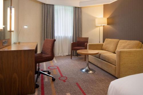 um quarto de hotel com um sofá e uma mesa em DoubleTree by Hilton Newbury North em Newbury