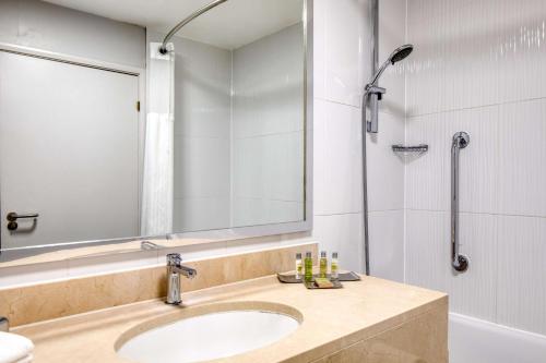 a bathroom with a sink and a mirror and a shower at Orida Hotels Newbury in Newbury