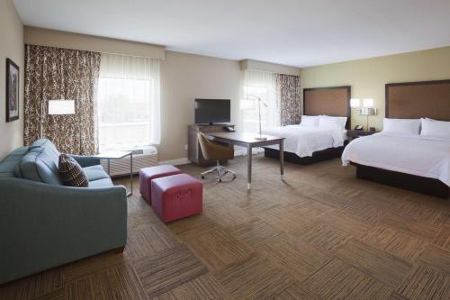 a hotel room with two beds and a desk at Hampton Inn Minneapolis-Roseville,MN in Roseville