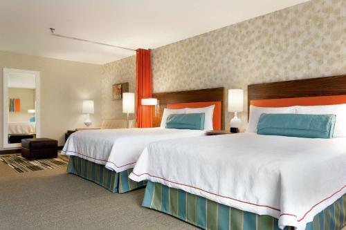 Habitación de hotel con 2 camas grandes y almohadas azules y rojas. en Home2 Suites By Hilton Richland en Richland