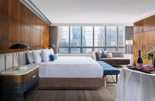 a hotel room with a large bed and a couch at The Marquette Hotel, Curio Collection by Hilton in Minneapolis